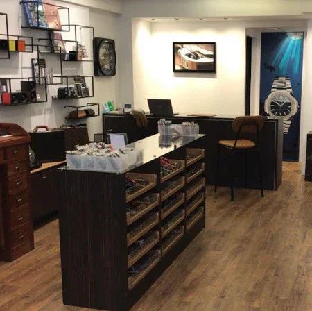 Intérieur d'une boutique d'accessoires horlogers avec vitrines, présentoirs et montres exposées.