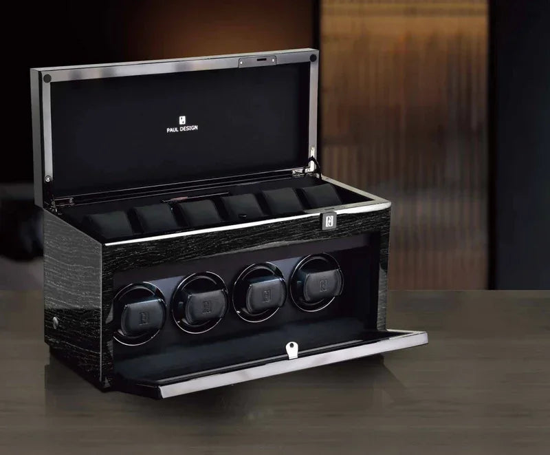 Boîte à montres noire moderne avec remontoirs automatiques intégrés sur une table.